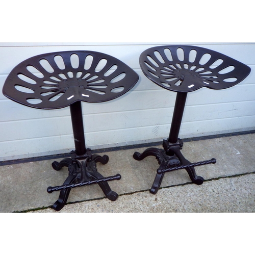 749 - Two reproduction tractor seat style stools