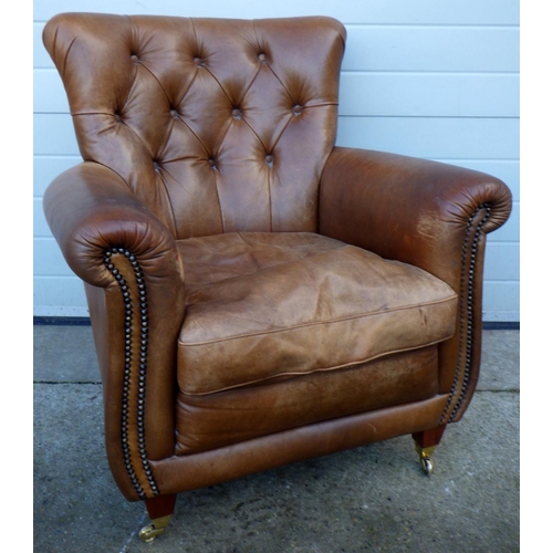 767 - A brown leather easy chair, marks