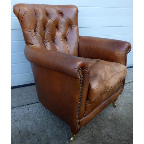 767 - A brown leather easy chair, marks