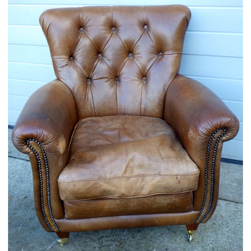 767 - A brown leather easy chair, marks