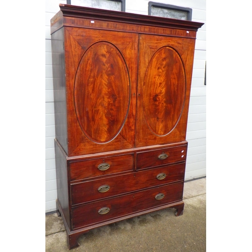 806 - A 19th cen mahogany linen press with oval panelled doors, 132cm wide, missing cornice side