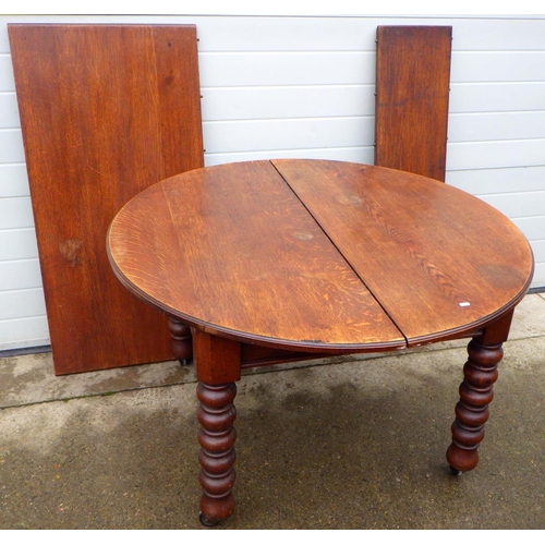 809 - A late Victorian oak wind out dining table with one and two half leaves on turned legs, approx 245cm... 