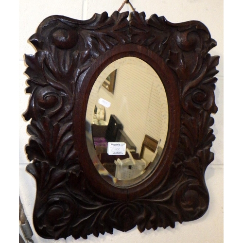 298 - A circular aluminium framed mirror 52cm diameter together with a carved oak mirror (2)