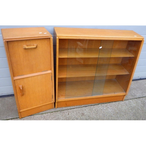 644 - A light oak low bookcase with sliding glass doors, 91cm wide together with a similar narrow cupboard... 