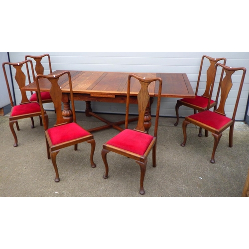 652 - A 1930's oak draw leaf table with X stretcher together with six oak Queen Anne style chairs (7)