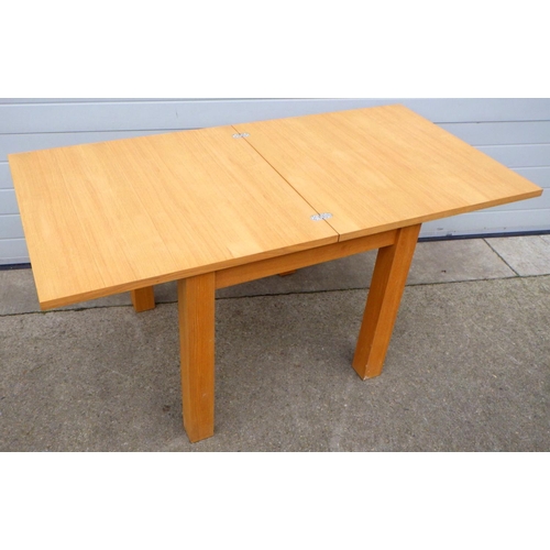 674 - A modern light oak dining table with fold out top, 81cm wide