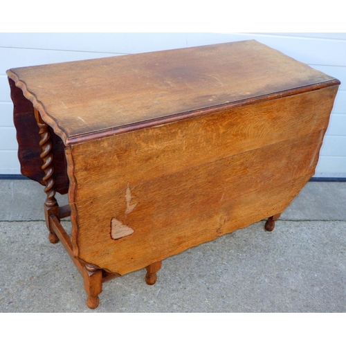 693 - A 1930's barleytwist oak gateleg table, 106cm across