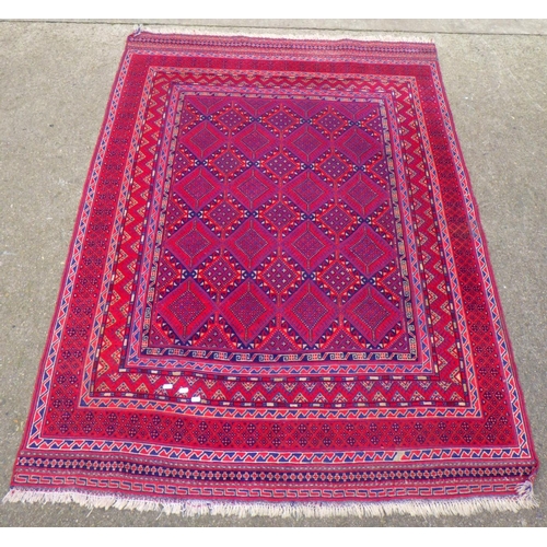 715 - A red ground rug, 202cm x 141cm