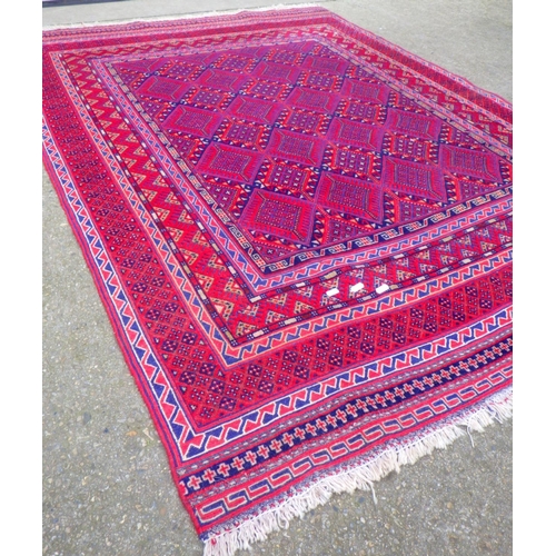 715 - A red ground rug, 202cm x 141cm