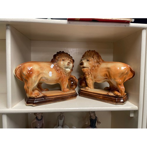 258 - A pair of Staffordshire style lions 27cm tall