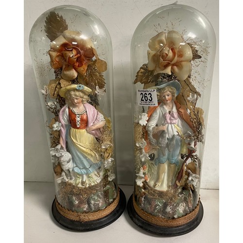 263 - A pair of late Victorian bisque figures sat under glass domes 39cm tall