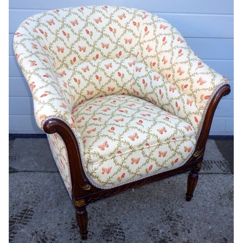 762 - A upholstered mahogany tub chair on turned and fluted legs