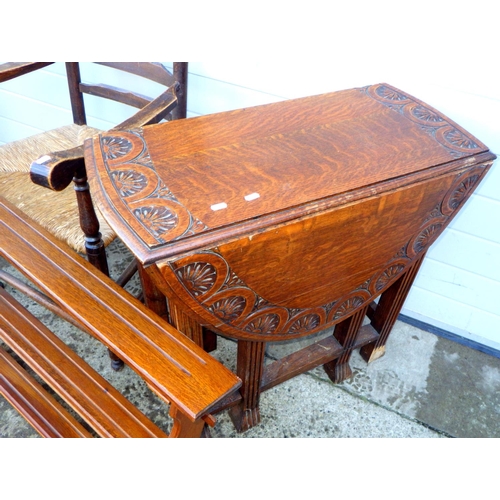 778 - A carved oak gateleg table, feet a/f together with a hanging shelf and a ladderback chair (3)
