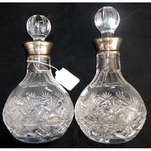 112 - A pair of silver collared decanters together with three silver topped bottles and a further long nar... 