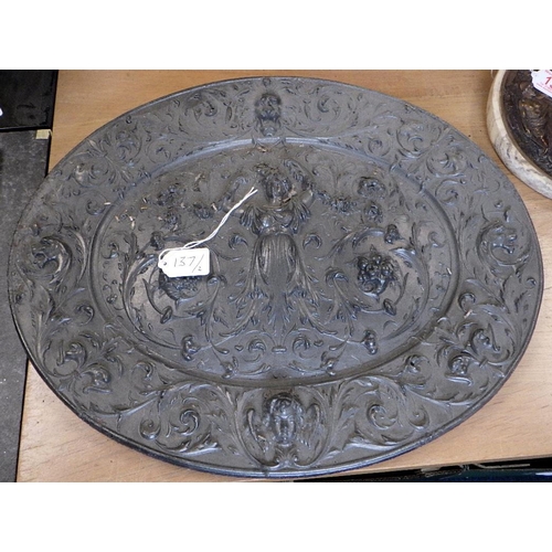 137 - An oval heavy cast metal relief plaque together with a circular wall plaques (2)