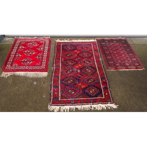 885 - Three various middle eastern red ground rugs, largest 100cm x 180cm (3)