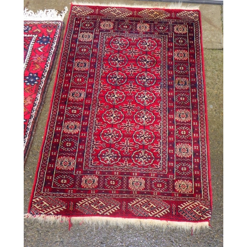 885 - Three various middle eastern red ground rugs, largest 100cm x 180cm (3)