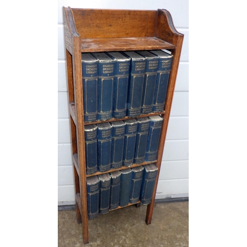 901 - A set of 18 Charles Dickens books within a narrow oak bookcase, 34cm wide