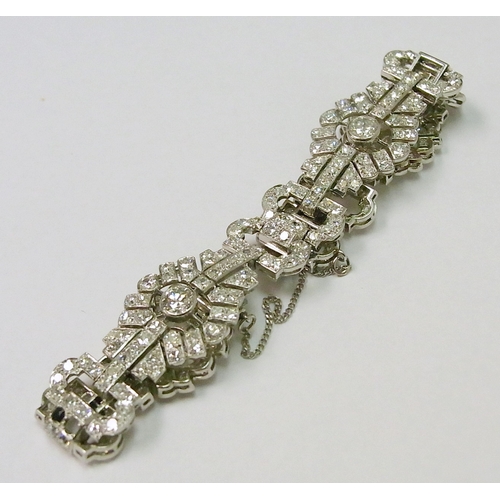 A fancy panel bracelet comprising mixed brilliant cut diamonds in a white metal setting, French bearing both eagle and dog heads marks.  A/F, missing three diamonds.  Approximately 190mm long / 17mm wide.