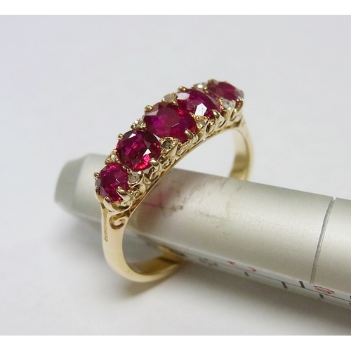 34 - An eternity ring comprising five graduated oval cut rubies and eight small rose cut diamonds in a ye...