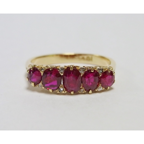 34 - An eternity ring comprising five graduated oval cut rubies and eight small rose cut diamonds in a ye... 