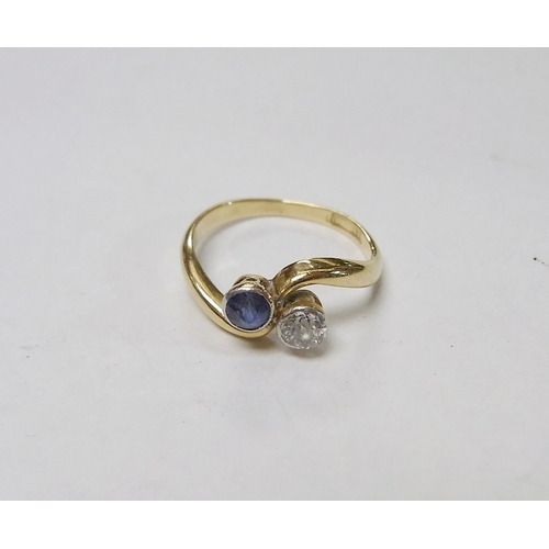 90 - A two stone twist ring set with a round cut diamond and a round cut sapphire, yellow metal marked 18... 