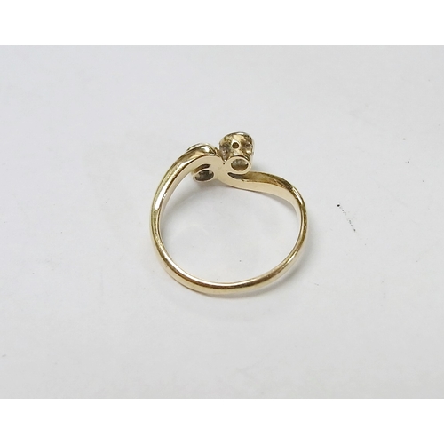 90 - A two stone twist ring set with a round cut diamond and a round cut sapphire, yellow metal marked 18... 