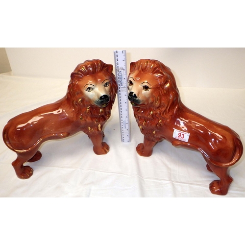 93 - A pair of 19thC Staffordshire lions with glass eyes, 30cm tall