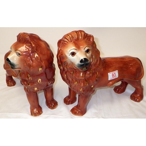 93 - A pair of 19thC Staffordshire lions with glass eyes, 30cm tall