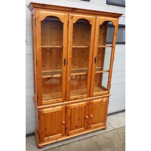 617 - A modern pine three door bookcase, 120cm wide