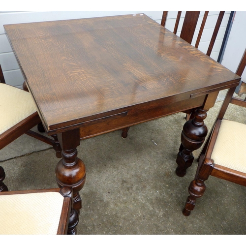 618 - A 1930's oak draw leaf table & four chairs