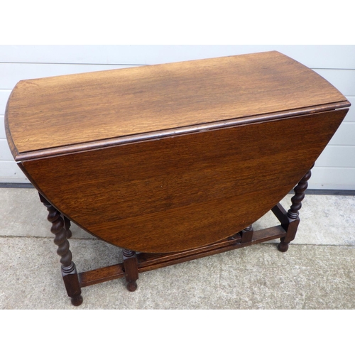 665 - A 1930's barleytwist oak gateleg table, 103cm across