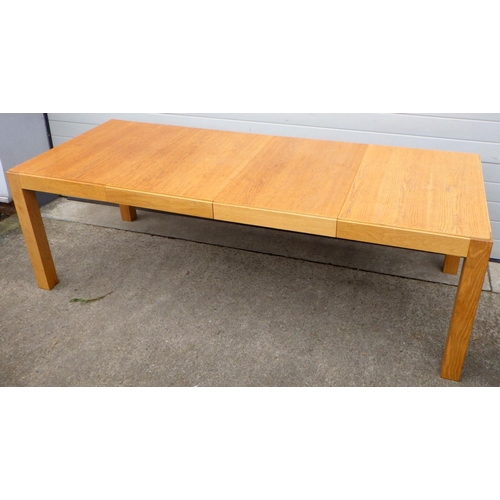 692 - A modern light oak table with two leaves, 234cm long extended, together with eight stacking office c... 