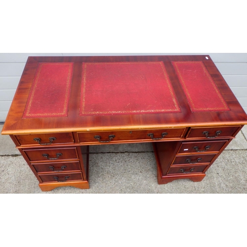 761 - A reproduction pedestal desk, with red leather inset top, 123cm wide