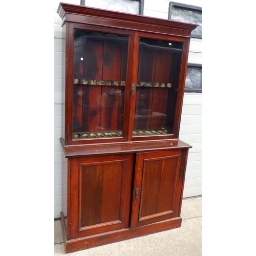 793 - An Edwardian two section bookcase, missing shelves, fitted for rifles, 122cm wide