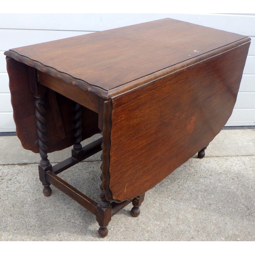 797 - A 1930's barleytwist oak gateleg table with wavy edge, 105cm across