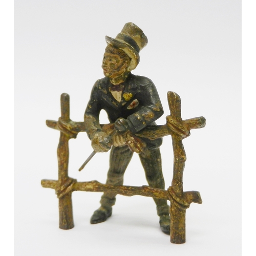 322 - A gentleman in a top hat leaning over a gate, cold painted bronze, unsigned.  75mm tall