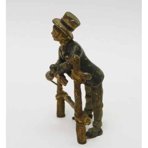 322 - A gentleman in a top hat leaning over a gate, cold painted bronze, unsigned.  75mm tall