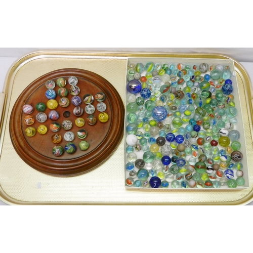 327 - A collection of  glass marbles together with a turned wood solitaire board.