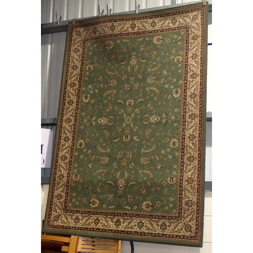 827 - A machine made green ground rug 230cm x 160cm