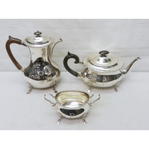A silver part tea and coffee set comprising an ebony handled teapot and coffee pot (this with partial lift-out filter bag) together with a two handled bowl.  William Hutton & Sons, Sheffield 1914/ 1915.  Each piece engraved with a "P".  1700g gross / teapot 295mm long / coffee pot 235mm tall.