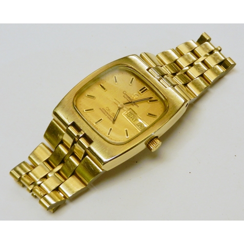 An Omega Constellation Automatic bracelet watch, reference 168.0059 TV-shaped case.  Gold plated having stainless steel case back, gold tone dial, day-date aperture at 3 o'clock.  With original guarantee booklet dated 1977 and a spare link.  33mm across head / 40mm lug-to-lug. WAS 61