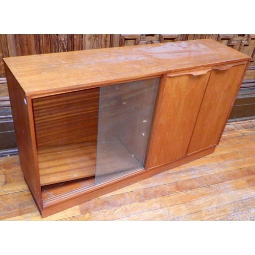 747 - A teak low cabinet with sliding glass doors, handle repaired, 136cm wide, ex Bootham Park Hospital