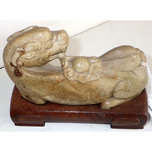 452 - A Chinese Qilin creature, carved hardstone modelled in a recumbent pose the legs tucked beneath the ... 