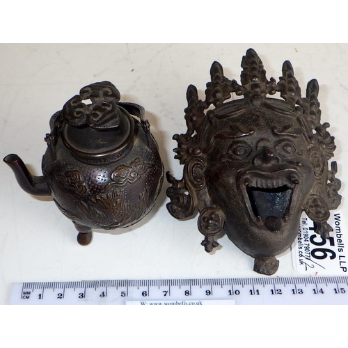 456 - A Chinese bronze miniature teapot standing on tripod feet, 10.5cm tall handle raised; a bronze mask?... 