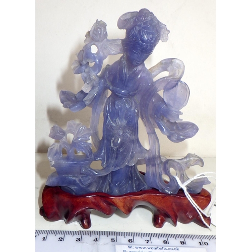 461 - A Chinese statuette depicting a female figure holding a fan and flowers, carving in purple hardstone... 