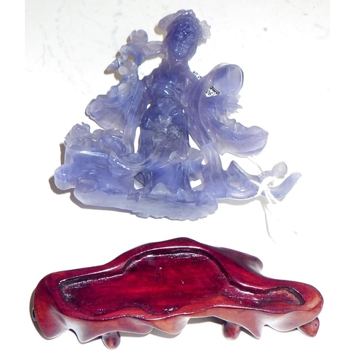 461 - A Chinese statuette depicting a female figure holding a fan and flowers, carving in purple hardstone... 