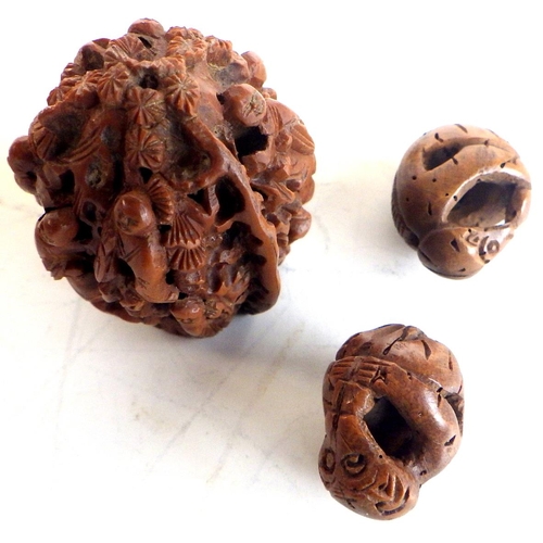 464 - A Chinese walnut shell, profusely carved with figures in foliage; another carved and pierced nut she... 