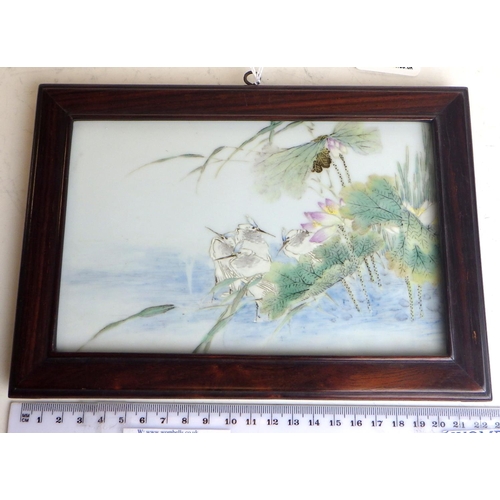 476 - A Chinese porcelain plaque painted with storks and lotus flowers at a lake edge, 18.5 x 11.5cm withi... 