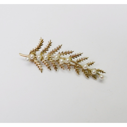 64 - A brooch modelled as a fern frond and set with 9 pearls.  50mm long / 4g gross